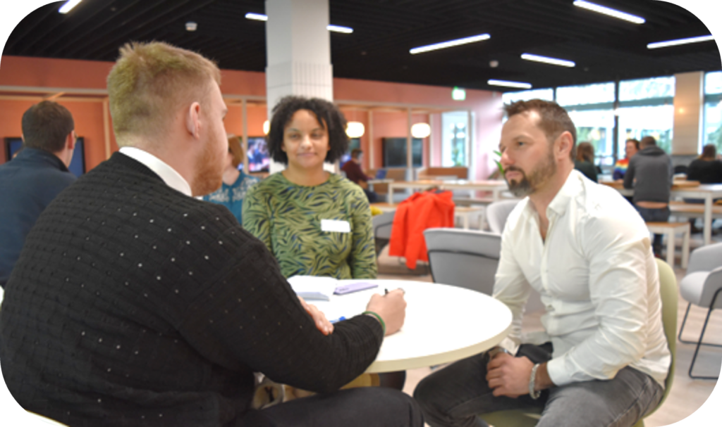 3 people talking at a table