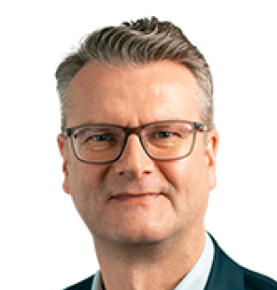 Headshot of Mark Dennis, General Counsel at Taylor & Francis, wearing a light blue shirt with a charcoal blazer
