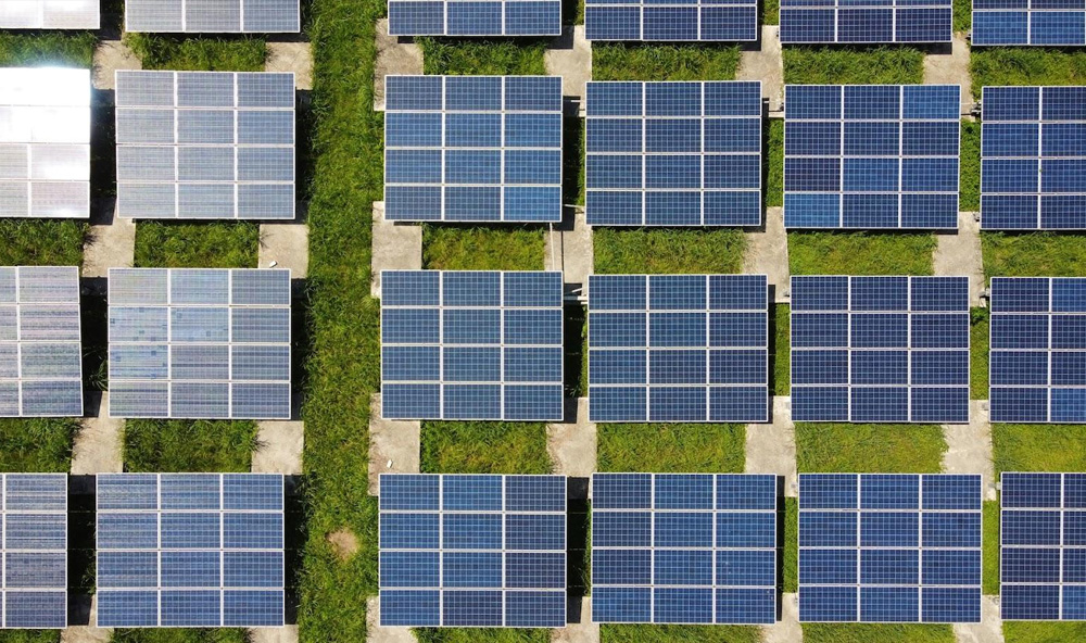 Solar panels over a grassy field.